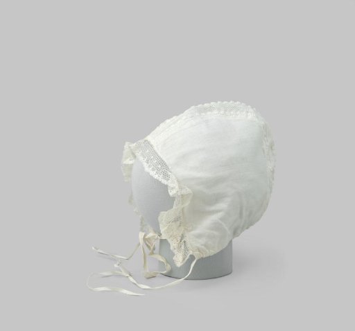 Baby cap of white textile with gathered applied strip of lace