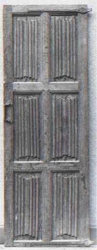 Door, divided by a partially profiled window into three pairs of standing rectangular panels with lettering