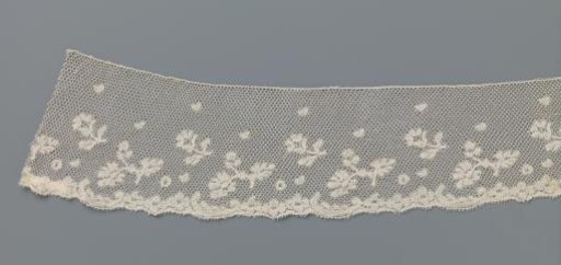 Strip of bobbin lace with two loose flower sprigs between a strew pattern