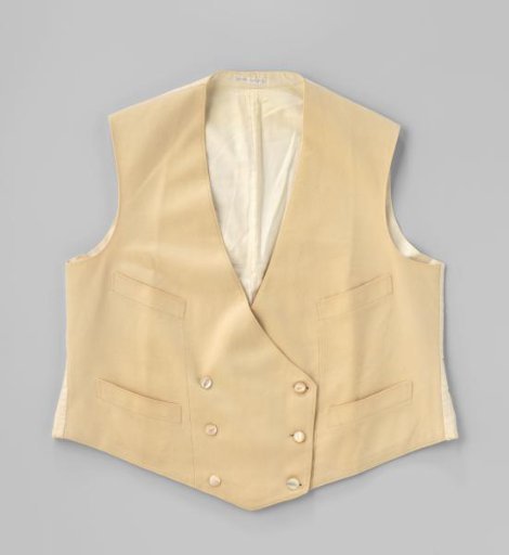 Jacket with four patch pockets and two times three mother-of-pearl buttons of cream-colored wool; the back with belt and buckle and the lining are of white cotton