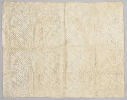 A child's bedspread of white, quilted satin with a bow border