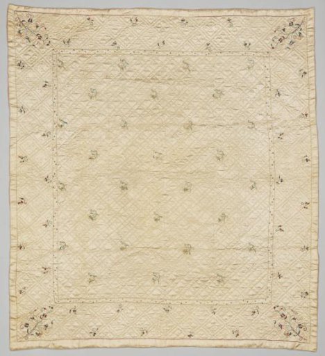 A baby's bedspread of white, quilted satin with a few flowers