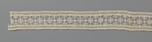 Strip of needle lace with small dense and large open circles