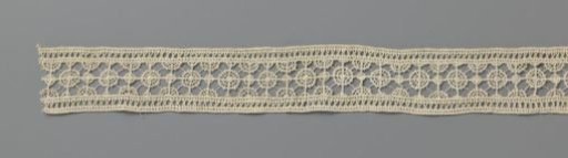 Strip of needle lace with small dense and large open circles