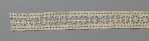 Strip of needle lace with small dense and large open circles
