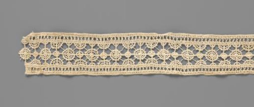 Strip of needle lace with small dense and large open circles