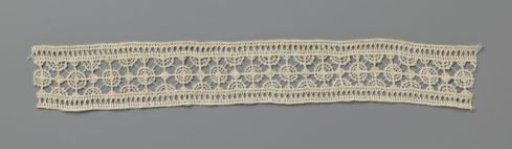 Strip of needle lace with small dense and large open circles