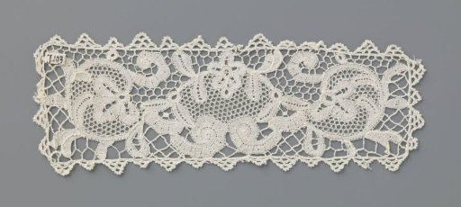 Ornamental piece of bobbin lace with volutes