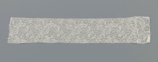 Strip of bobbin lace with hanging leaf and large spiders