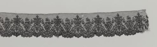 Strip of black bobbin lace with rose in U-shaped double ornamental border