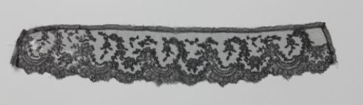 Strip of black bobbin lace with broken C-scrolls