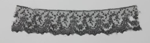 Strip of black bobbin lace with broken C-scrolls