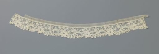 Strip of bobbin lace with volute scrolls and rosettes
