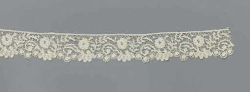 Strip of bobbin lace with S-scrolls
