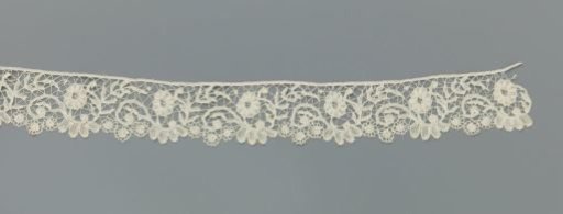 Strip of bobbin lace with S-scrolls