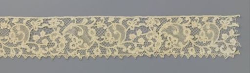 Strip of bobbin lace with volutes