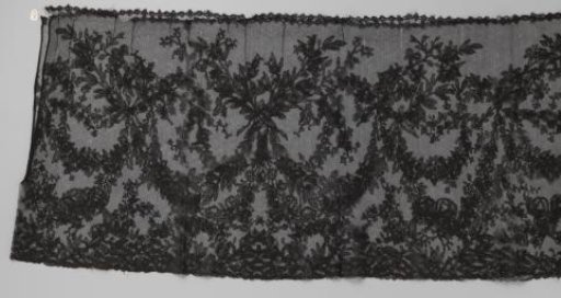 Japanese border of bobbin lace with a thin floral garland