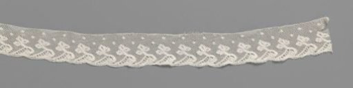 Strip of bobbin lace with trefoil on wave