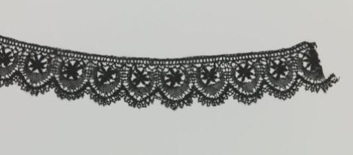 Strip of bobbin lace with star and crescent moon