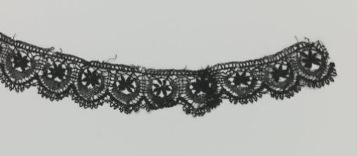 Strip of bobbin lace with star and half-moon
