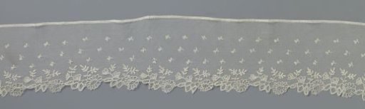 Strip of appliqué lace with openwork flower and leaf branch