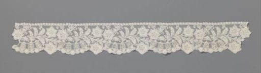 Strip of bobbin lace with shell on a pedestal