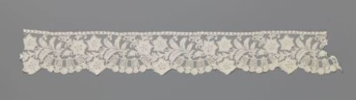 Strip of bobbin lace with shell on a pedestal