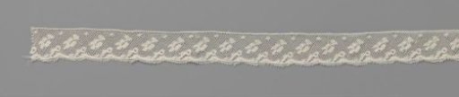Strip of bobbin lace with falling leaf