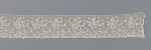 Strip of bobbin lace with lying flower branches