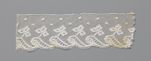 Strip of bobbin lace with trefoil on a wave