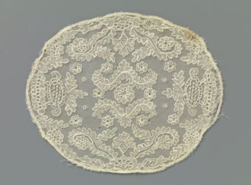Oval piece of lace embroidery on machine-made tulle with rosette flowers