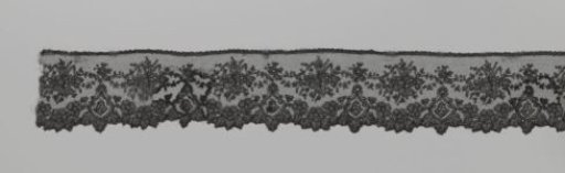 Strip of bobbin lace in Japanese style with shield-shaped medallions