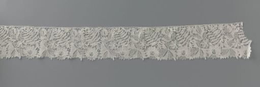 Strip of needle lace with cut-out leaf