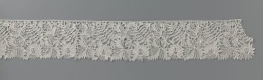 Strip of needle lace with cut-out leaf