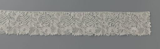 Strip of needle lace with cut-out leaf