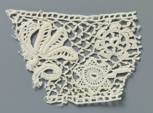 Fragment of crocheted lace with twisted branch and star-shaped flower