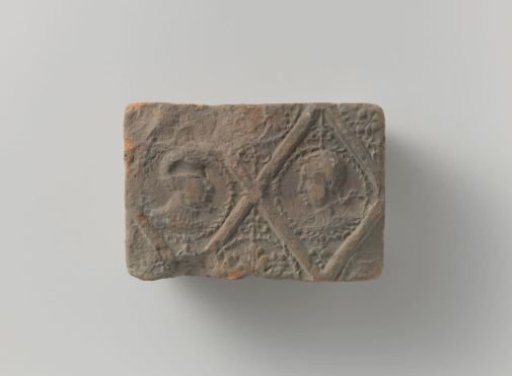 Fireplace tile with a representation of two male heads in diamonds