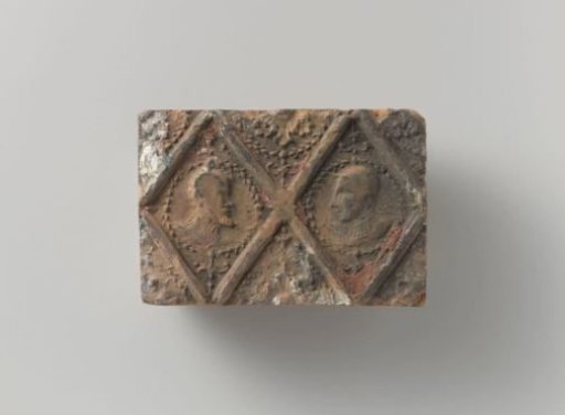 Fireplace stone with a representation of two male heads in lozenges