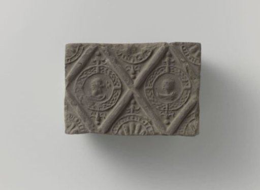 Fireplace stone with a representation of two male heads in lozenges