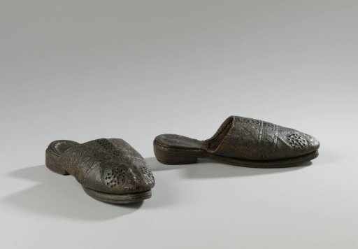 Mule of black leather with low heel and round toe, high vamp with perforations and incisions in striped pattern