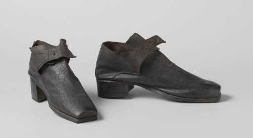 Shoe of black leather with a flattened, square toe, a high vamp over which two straps and a square heel