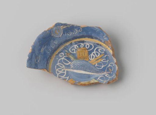 Fragment of reddish-fired earthenware, glazed blue on the front, with white circles on the flat surface over which a yellow building, blue leaf, and green and yellow spears appear to be depicted; stylized flower forms and diamonds in blue and white on the rim of the fragment