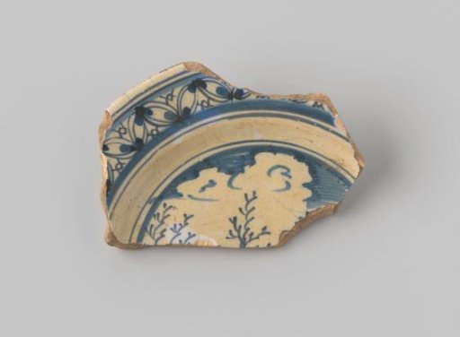 Sherd of yellowish-firing earthenware, glazed white, with a border and a painting of a sky with trees in blue on the front