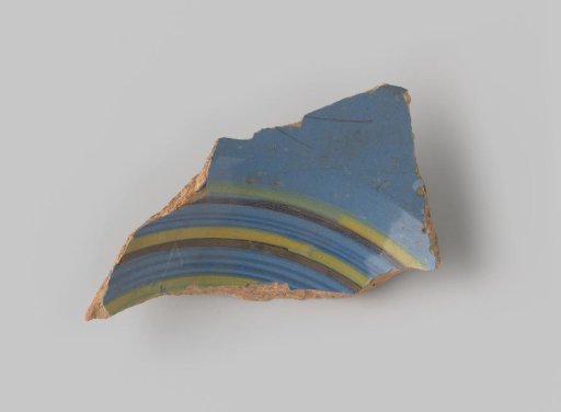 Fragment of red-firing earthenware, glazed on the upper side with blue glaze decorated with stripes in brown, yellow and green