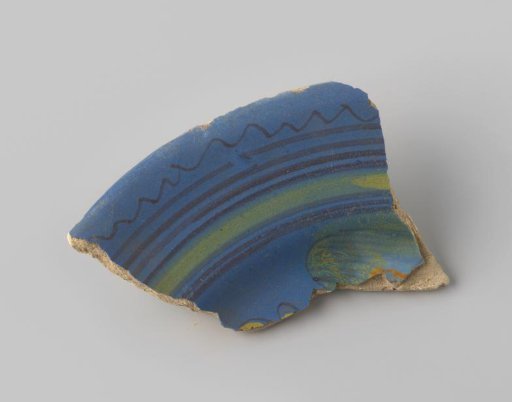 Fragment of red-firing earthenware, glazed on the upper side with blue glaze decorated with stripes and waves in brown and yellow