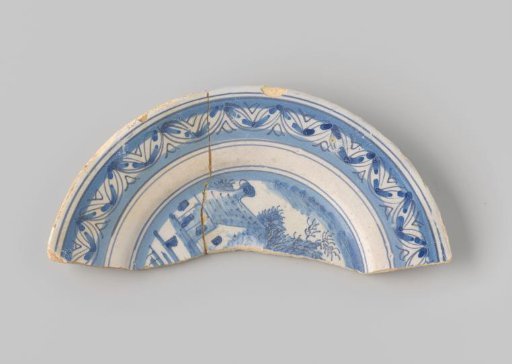 Sherd of yellowish-firing earthenware, glazed white, with a painting of a landscape and a border in blue glaze on the front