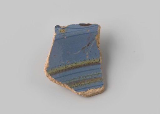 Fragment of red-firing earthenware, glazed on the upper side with blue glaze decorated with stripes in brown and yellow