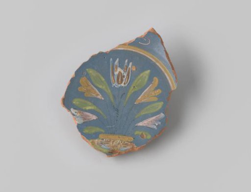Sherd of reddish-baked earthenware, glazed blue on the upper side with a decoration of a scene of five flowers growing in the earth in brown, white, yellow, orange and green, and several circles in brown and yellow around them