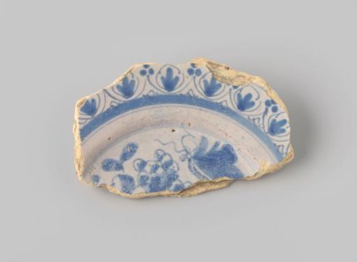 Sherd of yellowish-firing earthenware, glazed white, with a painting of fruit and a border in blue glaze on the front