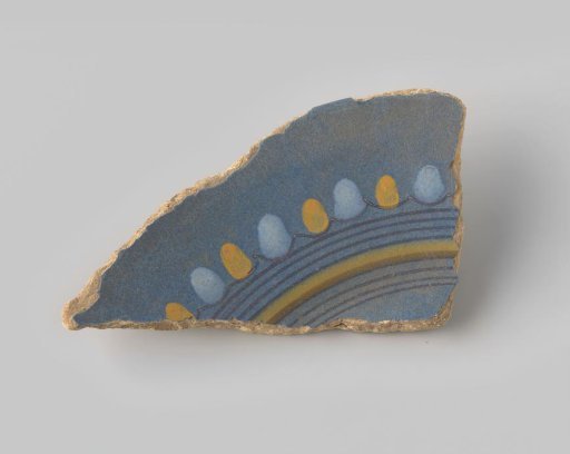 Fragment of reddish-fired earthenware, glazed blue on the upper side with decoration of a fragment of a circle in brown and yellow, and white and yellow dots